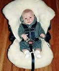 Baby in car seat with cover.