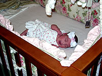 Infant in baby crib with mobile.